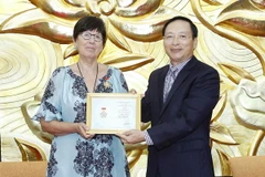 Phó Chủ tịch Liên hiệp các tổ chức hữu nghị Việt Nam Bùi Khắc Sơn trao tặng Kỷ niệm chương “Vì hòa bình, hữu nghị giữa các dân tộc” cho Đại sứ Đặc mệnh toàn quyền Vương quốc Bỉ tại Việt Nam Jehanne Roccas. (Ảnh: Văn Điệp/TTXVN)