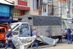 Lực lượng chức năng tiến hành tháo dỡ nhiều trường hợp nhà dân dựng mái che, biển hiệu chiếm vỉa hè đường Nguyễn Đình Chiểu (phường Đa Kao, quận 1). (Ảnh: Mạnh Linh/TTXVN)
