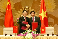 Tổng thư ký Quốc hội, Chủ nhiệm Văn phòng Quốc hội Nguyễn Hạnh Phúc và Đại sứ Hồng Tiểu Dũng trao Giấy chứng nhận bàn giao Dự án trao tặng Vật tư cho Quốc hội Việt Nam. (Ảnh: Văn Điệp/TTXVN)