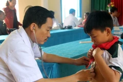 Khám sàng lọc bệnh viêm cầu thận cấp cho học sinh tại xã Hạnh Dịch. (Ảnh: Tá Chuyên/TTXVN)