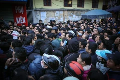 Chen lấn xô đẩy để lấy số thứ tự tiêm văcxin cho con mình. (Ảnh: Minh Sơn/Vietnam+)