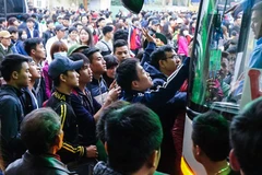 Khi có vé trong tay cũng chưa chắc lên được xe vì còn phải tranh giành với rất nhiều người khác để có được một chỗ ngồi yên ổn. (Ảnh: Minh Sơn/Vietnam+)