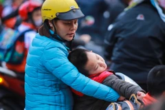 Việc phải đi học sớm trong thời tiết giá lạnh khiến nhiều em học sinh lộ rõ vẻ uể oải. (Ảnh: Minh Sơn/Vietnam+)