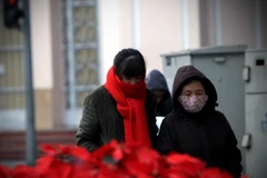 Người dân phải choàng áo và khăn ấm khi ra phố. (Ảnh: Trọng Đạt/TTXVN)