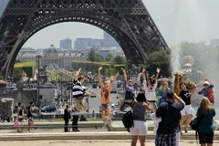 Khách du lịch bên Tháp Eiffel ở Paris (Pháp). (Nguồn: AFP/TTXVN)