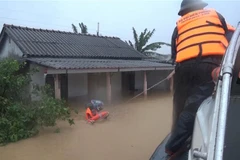 Bộ đội Biên phòng tỉnh Quảng Trị di dời những người dân bị mắc kẹt trong lũ đến nơi an toàn. (Ảnh: Hồ Cầu/TTXVN)