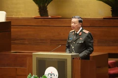 Bộ trưởng Bộ Công an Tô Lâm thừa ủy quyền của Thủ tướng Chính phủ trình bày Tờ trình về dự án Luật Lực lượng tham gia bảo vệ an ninh, trật tự ở cơ sở. (Ảnh: Dương Giang/TTXVN)