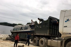 Tàu thủy của anh Chuẩn được cho lên ô tô để vận chuyển vào miền Trung. (Ảnh: Nguyễn Việt Dũng/TTXVN)