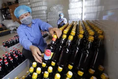 Dán mác sản phẩm nước mắm Ninh Cơ tại Công ty. (Ảnh: Trần Việt/TTXVN)