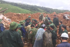 Các lực lượng đưa thi thể người bị nạn ra bên ngoài.(Ảnh: TTXVN phát)