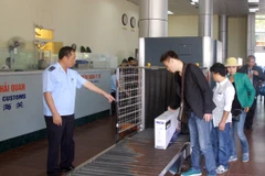 Nhân viên hải quan giám sát hành lý của khách nhập cảnh qua cửa khẩu Móng Cái. (Ảnh: Hoàng Hùng/TTXVN)