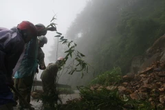 Công nhân Hạt Giao thông 4 thu dọn đất đá ở những điểm sạt lở trên tuyến đường lên Khu du lịch Mẫu Sơn, Lạng Sơn. (Ảnh: Doãn Hoàng Nam/TTXVN) 
