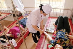 Bác sỹ Trung tâm Y tế huyện Yên Bình chăm sóc cho nạn nhân bị ngộ độc thực phẩm. (Ảnh: Trung Kiên/TTXVN)