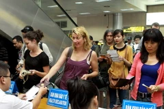 Kiểm tra tờ khai y tế của khách nhập cảnh. (Ảnh: Dương Ngọc/TTXVN)