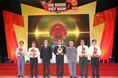 Chủ tịch nước Trương Tấn Sang tặng biểu tượng Quốc huy Việt Nam cho 5 cá nhân đại diện cho 5 vùng đất thiêng liêng của Tổ quốc tại buổi lễ. (Ảnh: Nguyễn Khang/TTXVN)