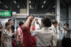 Nhân viên sân bay quốc tế Hong Kong (Trung Quốc) kiểm tra thân nhiệt của hành khách để ngăn ngừa khả năng lây lan dịch MERS ngày 5/6 vừa qua. (Ảnh: AFP/TTXVN)