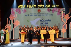 Ông Đào Minh Tuấn, Phó Tổng Giám đốc Vietcombank (hàng đầu, đứng giữa) trao tặng số tiền ủng hộ Quỹ Bảo trợ trẻ VN. (Nguồn: Vietcombank)