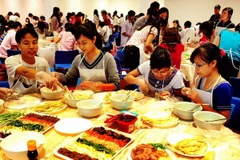 Các bạn học sinh, sinh viên Việt Nam tự mình làm các món ăn Hàn Quốc. (Ảnh: Thanh Hà/TTXVN)