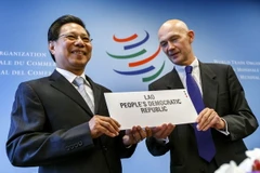 Bộ trưởng Công Thương Lào Nam Viyaketh (trái) và Tổng giám đốc WTO Pascal Lamy (phải) trong lễ ký xác nhận Lào là thành viên mới của WTO tại trụ sở WTO ở Geneva ( Thụy Sĩ ) ngày 26/10. AFP-TTXVN