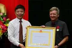 Chủ tịch UBND tỉnh Quảng Bình Nguyễn Hữu Hoài trao tặng Huân chương Lao động hạng Ba cho ông Howard Limbert. (Ảnh: Đức Thọ/TTXVN)