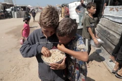 Các em nhỏ được phát bữa ăn cứu trợ tại Khan Younis, Dải Gaza. (Ảnh: THX/TTXVN)