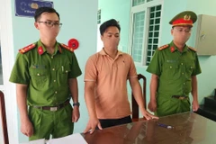 Cơ quan Công an tống đạt quyết định khởi tố vụ án, khởi tố bị can và lệnh bắt đối tượng Nguyễn Văn Hoàn. (Ảnh: TTXVN phát)