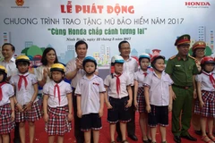 Việc đội mũ bảo hiểm đạt chuẩn sẽ giúp học sinh phòng tránh được những tai nạn giao thông. (Ảnh: Doãn Đức/Vietnam+)