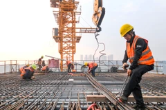 Công nhân làm việc tại công trình xây dựng ở Trùng Khánh (Trung Quốc). (Ảnh: THX/TTXVN)