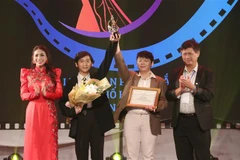 Ban Tổ chức trao Giải Vàng hạng mục phim hoạt hình cho Chu Tất Thắng và Chu Tấn Phát. (Ảnh: Thu Hương/TTXVN)
