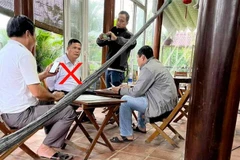 Đặng Ngọc Bảo (áo trắng, gạch đỏ) bị bắt quả tang đang nhận 9,8 triệu đồng. (Nguồn: VTC)