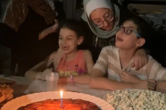 Hashem mừng sinh nhật thứ 12 của mình với chiếc bánh dứa yêu thích, cùng với mẹ Hiba và em gái Basma. (Nguồn: CNN/Ảnh chụp màn hình)