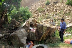 Đất, đá tảng trên núi sạt trượt xuống khu vực chân núi làm hư hỏng nhiều tài sản của người dân. (Ảnh: Nguyễn Nam/TTXVN)