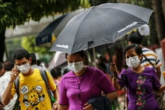 Người dân đeo khẩu trang đề phòng lây nhiễm virus H1N1 tại Yangon, Myanmar ngày 24/7. (Nguồn: EPA/TTXVN)