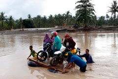 Người dân sơ tán khỏi các khu vực ngập lụt sau khi bão Tembin quét qua tỉnh Lanao del Norte ngày 23/12. (Nguồn: THX/TTXVN)