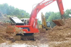 Phương tiện cơ giới nỗ lực xuyên đêm để thông tuyến Quốc lộ 40B. (Ảnh: Đoàn Hữu Trung/TTXVN)
