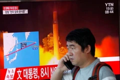 Người dân Hàn Quốc đi qua màn hình đưa tin về việc Triều Tiên phóng tên lửa. (Nguồn: Reuters)