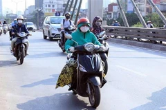 Người dân trang bị cho mình những trang phục bịt kín để chống chọi với nắng nóng gay gắt. (Ảnh: Quang Quyết/TTXVN)