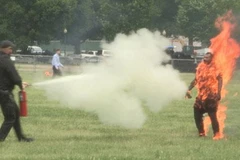 Cảnh sát dùng bình chữa cháy dập lửa trên người nạn nhân. (Nguồn: New York Post)