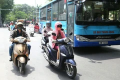 Người dân trang bị từ đầu đến chân để chống chọi lại cái nắng rát của mặt đường phả lên. (Ảnh: Danh Lam/TTXVN)