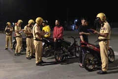 Công an thành phố Thủ Dầu Một tiến hành lập hồ sơ xử lý nghiêm các đối tượng đua xe trái phép. (Ảnh: Nguyễn Văn Việt/TTXVN)