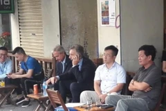 Tổng thống Argentina Mauricio Macri (cầm điện thoại) ngồi càphê vỉa hè Hà Nội. (Nguồn: Clarin)