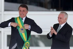 Tổng thống mãn nhiệm của Brazil Michel Temer (phải) trao khăn choàng biểu tượng cho Tổng thống đắc cử Jair Bolsonaro (trái) tại lễ tuyên thệ nhậm chức ở Brasilia ngày 1/1/2019. (Nguồn: THX/TTXVN)