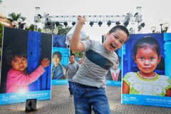 Trẻ nhỏ Thủ đô tại triển lãm ảnh Thắp sáng nụ cười Việt Nam. (Ảnh: Thành Đạt/TTXVN)