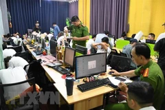 Cơ quan chức năng kiểm tra, khám xét, thu giữ vật chứng tại nơi làm việc của các đối tượng liên quan trong vụ án. (Ảnh: TTXVN phát)