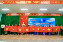 Đại diện lãnh đạo tỉnh Thanh Hóa và báo Người lao động tặng cờ tổ quốc cho người dân. Ảnh: Trịnh Duy Hưng - TTXVN