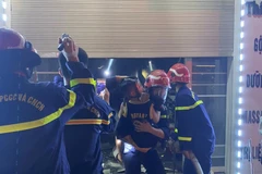 Lực lượng chức năng đưa nạn nhân mắc kẹt thoát khỏi đám cháy. (Nguồn: An ninh Hải Phòng)