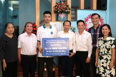 Phó Chủ tịch Ủy ban Nhân dân tỉnh Hà Giang Trần Đức Quý trao thưởng cho em Hoàng Tuấn Dũng. (Ảnh: Minh Tâm/TTXVN)