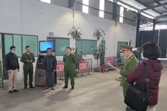 Công an đọc lệnh khám xét Trung tâm Đăng kiểm xe cơ giới 29-13D. (Nguồn: Người Lao Động)