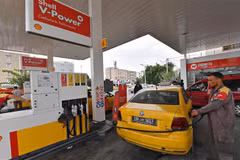 Nhân viên bơm xăng cho phương tiện tại một trạm xăng ở Tunis (Tunisia). (Ảnh: AFP/TTXVN)