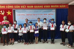 Ông Nguyễn Trọng Đàm - Chủ tịch Hội Bảo tuy Người Khuyết tật và Trẻ em mồ côi Việt Nam và ông Phan Thanh Duy - Phó Chủ tịch Ủy ban Nhân dân tỉnh Bạc Liêu trao học bổng tại chương trình. (Ảnh: Tuấn Kiệt/TTXVN)